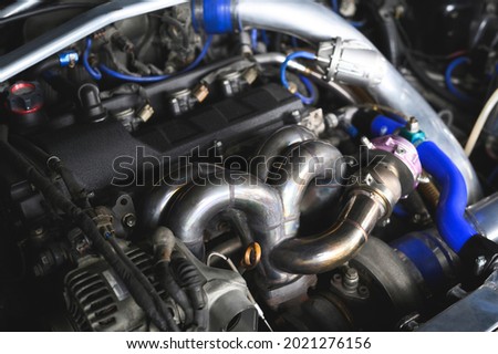 Welding fabrication stainless steel turbo and wastegate manifold header ,exhaust manifolds in turbocharged racing car. Royalty-Free Stock Photo #2021276156