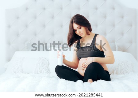 Pregnant Woman Rubbing Cream Anti-Stretchmarks on her Stomach. Mother to be massaging her skin with lotion preventing after birth problems 
 Royalty-Free Stock Photo #2021285441