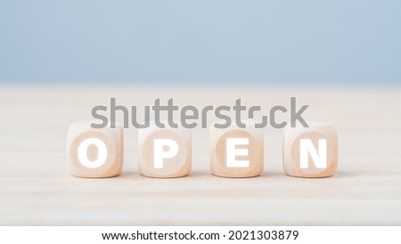 wooden cubes with text open in white on a wooden block surface. Open concept.