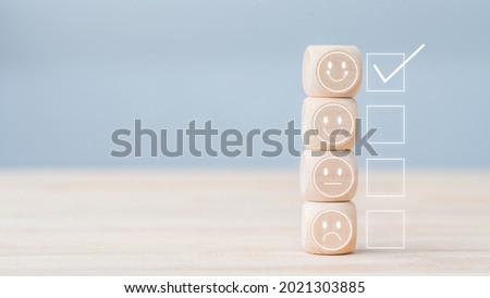 smile face on woodblock cube icon to give satisfaction in service. feedback rating and positive customer review experience, service, and Satisfaction, rating very impressed. Mental Health Assessment.
