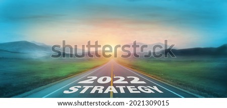 New year 2022 or start straight concept. Text 2022 and strategy written on the road with sunrise background. Concept of goal and challenge or career path, success, opportunity, change and hope. Royalty-Free Stock Photo #2021309015