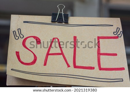 Sale text  written in red ink attach with black clip.