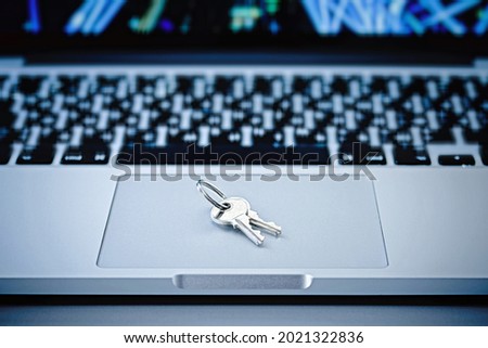 Close-up of a bunch of keys on the background of a modern laptop. Personal information protection concept.