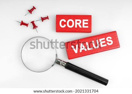 Business concept. On a white background, a magnifying glass and red plates with the inscription - CORE VALUES