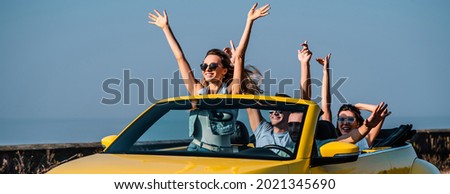 The four friends travel in a yellow cabriolet Royalty-Free Stock Photo #2021345690