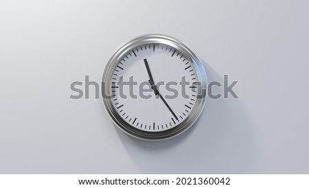Glossy chrome clock on a white wall at twenty-four past eleven. Time is 11:24 or 23:24 Royalty-Free Stock Photo #2021360042