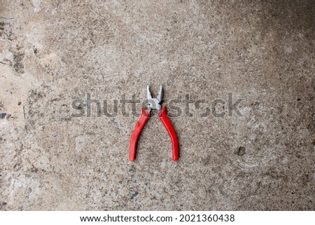 Crocodile mouth pliers. Hand tools laid on cement floor