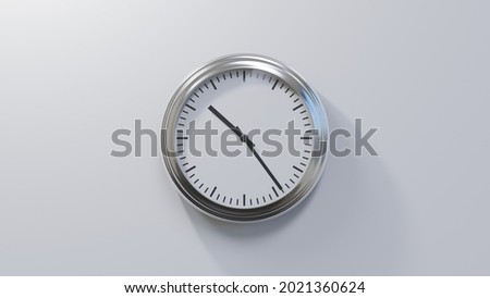 Glossy chrome clock on a white wall at twenty-four past ten. Time is 10:24 or 22:24 Royalty-Free Stock Photo #2021360624