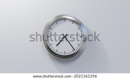 Glossy chrome clock on a white wall at twenty-four past seven. Time is 07:24 or 19:24 Royalty-Free Stock Photo #2021361296