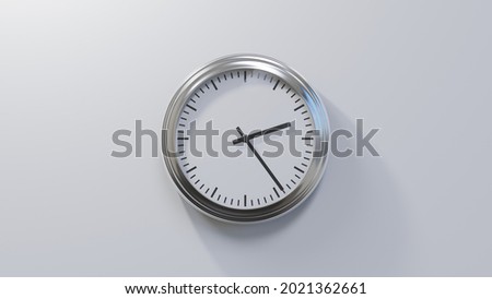 Glossy chrome clock on a white wall at twenty-four past two. Time is 02:24 or 14:24 Royalty-Free Stock Photo #2021362661