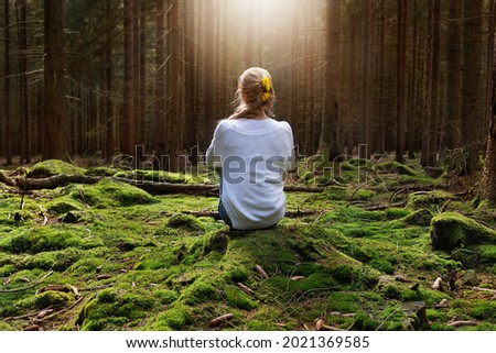 Woman sitting in forest enjoys the silence and beauty of nature. Royalty-Free Stock Photo #2021369585