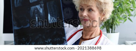 Elderly doctor woman is holding x-ray closeup