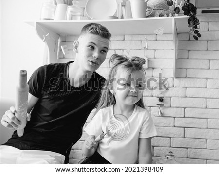 caucasian funny cute siblings in kitchen - little girl with older brother baking in kitchen. Bake, duty, fun and culinary concept