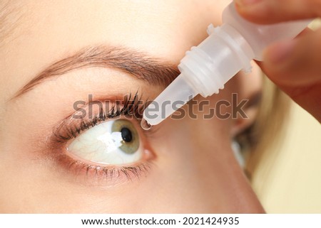 Young woman using eye drops on light background, closeup Royalty-Free Stock Photo #2021424935