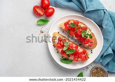 Sandwiches with fried toast, feta and tomatoes on a gray background. Italian bruschetta. Royalty-Free Stock Photo #2021454422