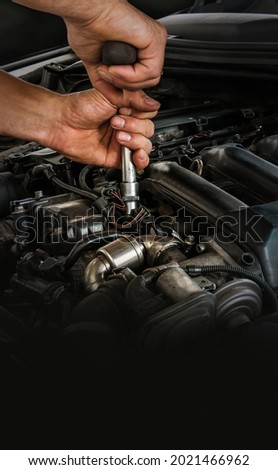 Auto mechanic working on car engine in mechanics garage. Repair service. Close-up shot. Free space for text, copy space Royalty-Free Stock Photo #2021466962