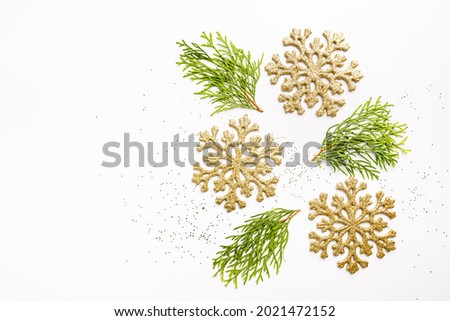 Christmas gold decorations with thuja branches on white background, top view. Winter Decoration Background