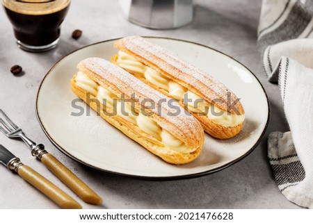 Traditional french eclairs filled with vanilla cream and powdered sugar. Royalty-Free Stock Photo #2021476628