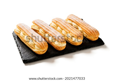 Traditional french eclairs filled with vanilla cream and powdered sugar. isolated on white background Royalty-Free Stock Photo #2021477033