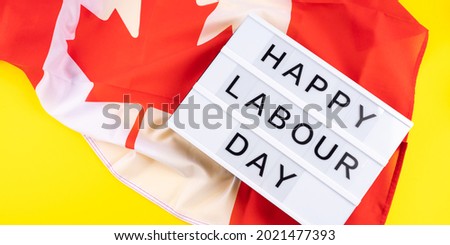 Happy Labor Day greetings text on llightbox on yellow background with canadian flag, national september holiday