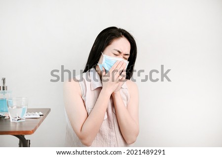 unhealthy woman wear face mask is sneezing  and look illness.