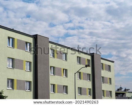 green apartment building against the blue sky in sunny weather