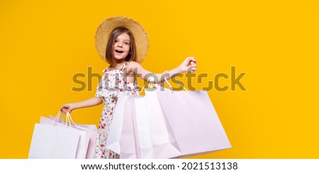 Portrait Of Joyful Teen Girl In Straw Hat With Bright Shopping Bags Over Yellow Background, Copy Space. 