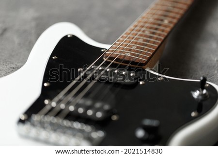 Electric guitar black and white color, detail. Music instruments. Concept international music day. Electrical guitar neck and metal strings. Macrophotography. Soft focus