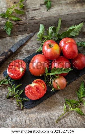 Organic healthy raw ripe pink tomatoes on a kitchen wooden table. The concept of Diet menu and harvesting. Copy space.