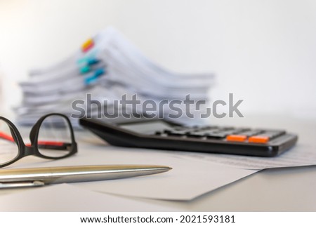 Pile of paper with colorful clips. , calculator, pen placed on a business desk in a business office. Copy space