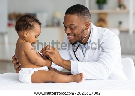 Black Male Pediatrician Listening Infant Child's Heartbeat With Stethoscope During Checkup At Home, Smiling African American Pediatrist Doctor Checking Baby's Heart And Lungs, Closeup Shot Royalty-Free Stock Photo #2021617082