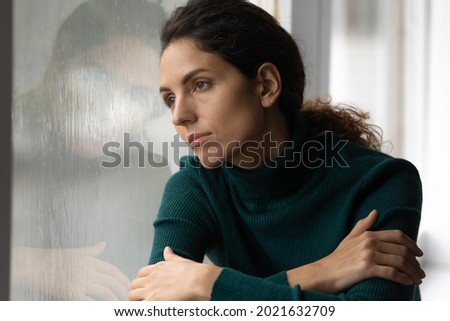 Close up thoughtful upset woman looking in rainy window alone, lost in thoughts, pensive unhappy young female feeling lonely and depressed, thinking about relationship or personal problems Royalty-Free Stock Photo #2021632709