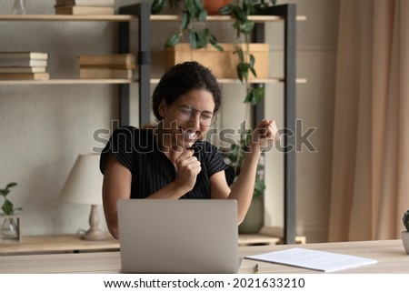 Close up overjoyed businesswoman in glasses celebrating success, yes gesture, using laptop, sitting at desk, excited woman received good news in message, project results, student get scholarship Royalty-Free Stock Photo #2021633210
