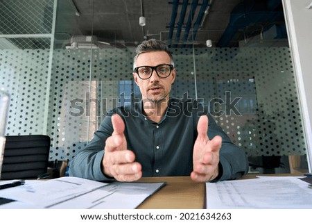 Mature business man executive coach talking to web camera on video conference call virtual meeting, professional training negotiation remote working doing online presentation in office. Webcam view Royalty-Free Stock Photo #2021634263