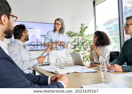 International executive team people having board meeting discussing project results. Diverse employees group working with senior leader brainstorming in office meeting room at presentation training. Royalty-Free Stock Photo #2021639267