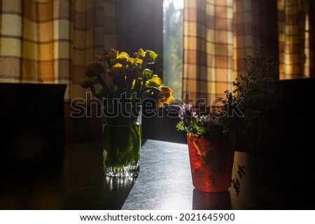 Bouquets of wild flowers are in glasses on the table