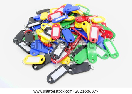 One hundred pieces of multi-colored key chains with a paper insert. There are a lot of them lying in a pile. A keychain with an inscription. Keys with mockup badge with copy space, key card 