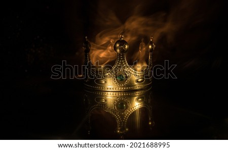 low key image of beautiful kings crown over wooden table. vintage filtered. fantasy medieval period. Selective focus. Colorful backlight Royalty-Free Stock Photo #2021688995