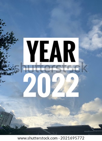 Happy new year 2022 on blue sky background with little sparkle from sunshine