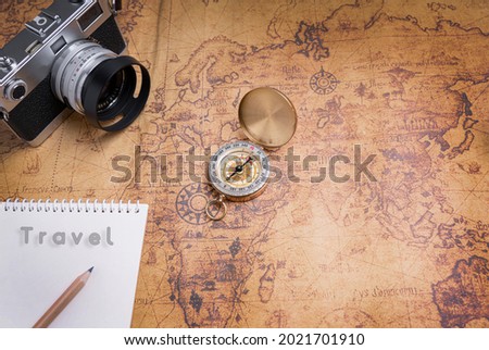 Vintage Compass and camera on map for travel planning