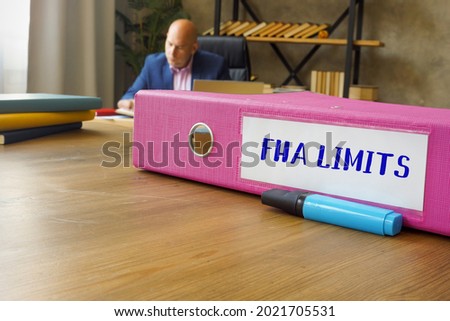 Conceptual photo about FHA LIMITS with written phrase. Businessman working at work table 
