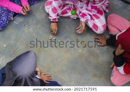 Children play a Traditional Indonesian Children's Games called bekel ball, Bekelan, or beklen which originates from central Java Royalty-Free Stock Photo #2021717591