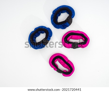 Multicolored hand weights of blue and pink colors for fitness classes on a white background top view