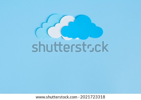 Light blue, white and blue paper cut clouds on blue background with copy space. 