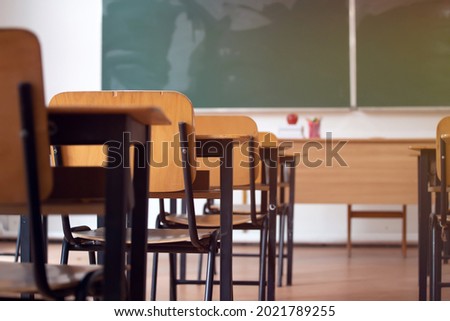Back to School Concept. Empty classroom with chairs, desks and chalkboard.