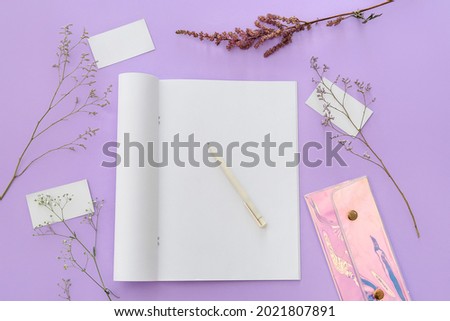 Blank magazine, flowers and pen on color background