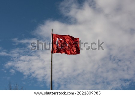 Turkish national flag with white star and moon on a pole in sky