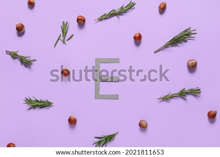 Letter E with healthy nuts and herbs on color background Royalty-Free Stock Photo #2021811653