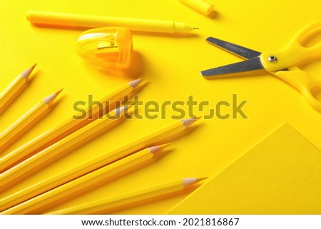 Pencils, scissors and sharpener on color background
