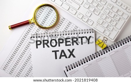PROPERTY TAX text written on a notebook on the chart with keyboard and planning